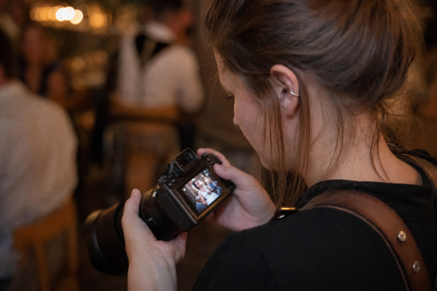 Photographer reviewing candid shots on the back of her camera